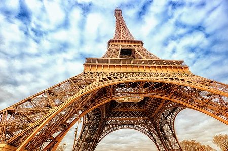 Vista ravvicinata della Torre Eiffel contro un cielo nuvoloso.