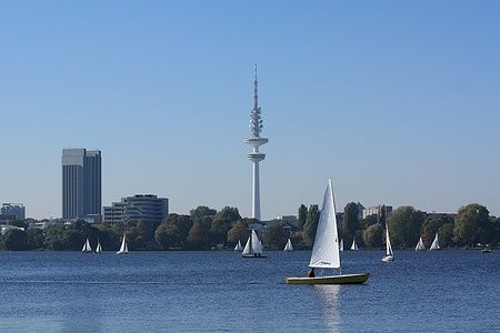 Barche a vela sull'Aussenalster ad Amburgo con la torre della televisione sullo sfondo.
