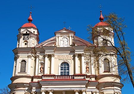 Facciata della chiesa di San Pietro e San Paolo a Vilnius sotto un cielo blu.