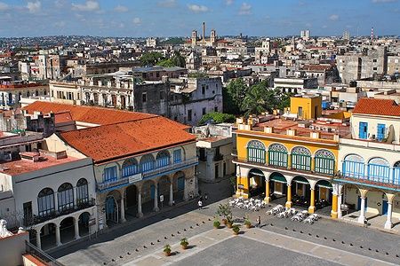 Plaza Vieja all'Avana con edifici colorati e un cortile ampio.