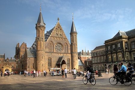 Ridderzaal nel Binnenhof con persone e biciclette nella piazza.