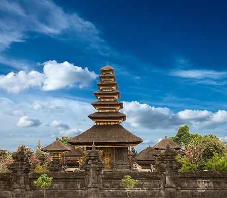 Il tempio hindu Besakih a Bali con un cielo blu e vegetazione rigogliosa.