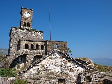 Torre dell'orologio del castello di Gjirokastra in Albania sotto il cielo azzurro.