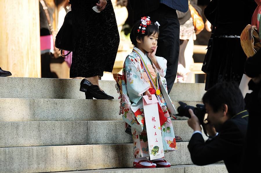 Bambino caucasico, boy, 5 anno di età, vestita in kimono giapponese e il  piano di calpestio con cautela attraverso sacrario scintoista cortile come  se lo spunto da fermi senza un suono Foto