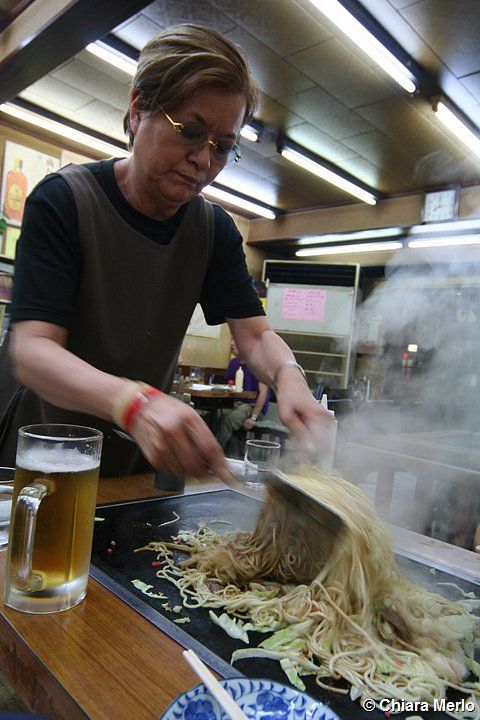 un uomo prepara gli yakisoba