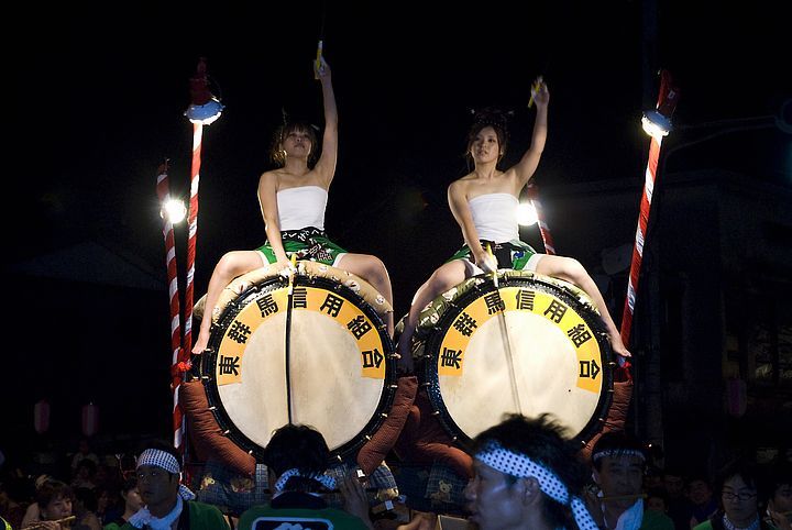 Due ragazze sedute sui tradizionali tamburi taiko durante il Nebuta Matsuri.