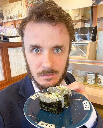 Marco Togni con piatto di gunkan con shirasu in un ristorante giapponese.