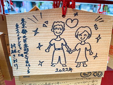 Una tavoletta votiva in legno con disegni di un uomo e una donna appesa presso il santuario Kanda Myojin.