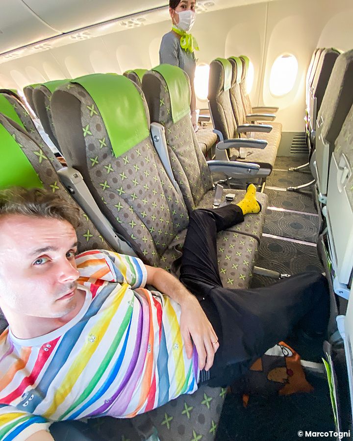 Marco Togni disteso sui sedili di un aereo in Giappone con una donna, Marco Togni che lavora come assistente di volo, alle...