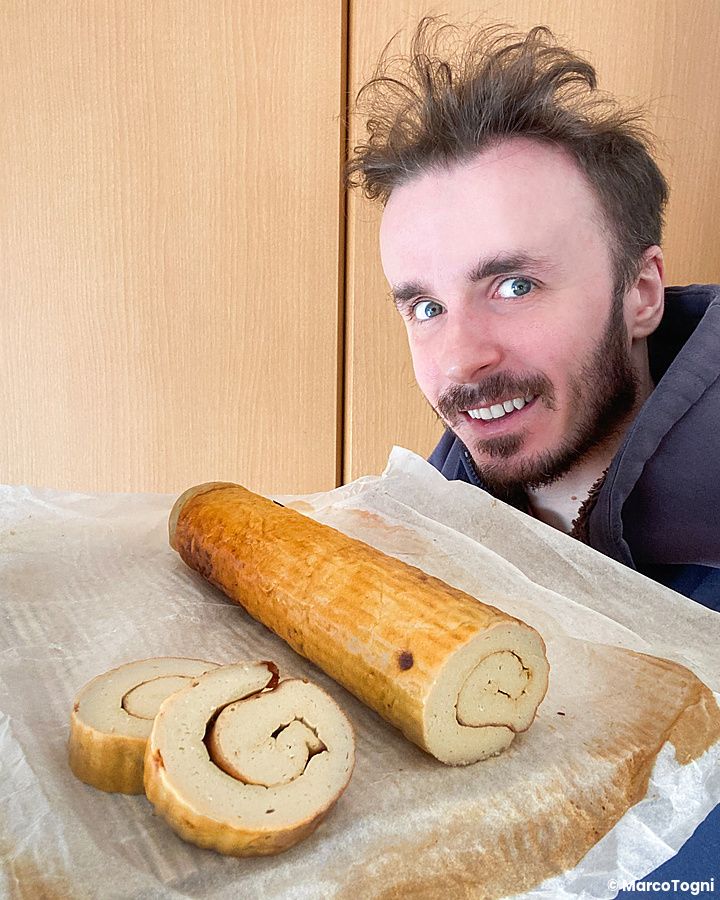 Marco Togni sorridente con accanto un rotolo di datemaki su carta da forno.