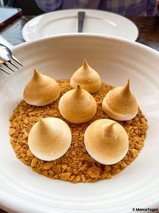 Dolce con meringhe dorate su base di granella in una ciotola bianca presso il ristorante THE APOLLO a Ginza.