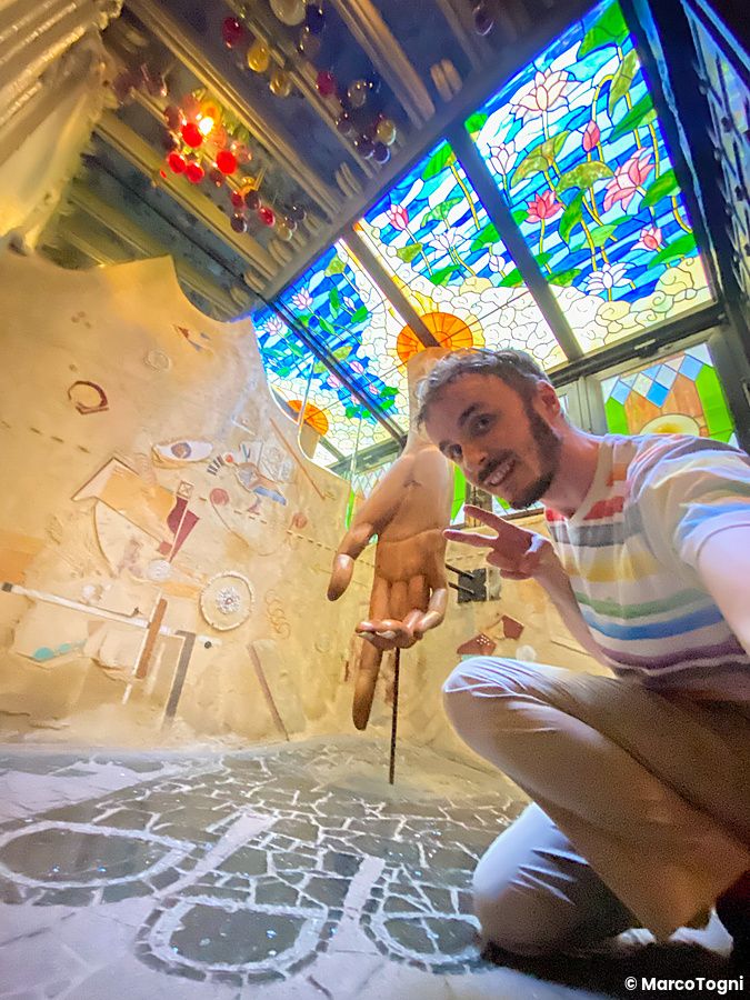 Marco Togni si scatta un selfie all'interno, al piano terra, presso El Dorado a Waseda, circondato da vetrate e decorazioni.
