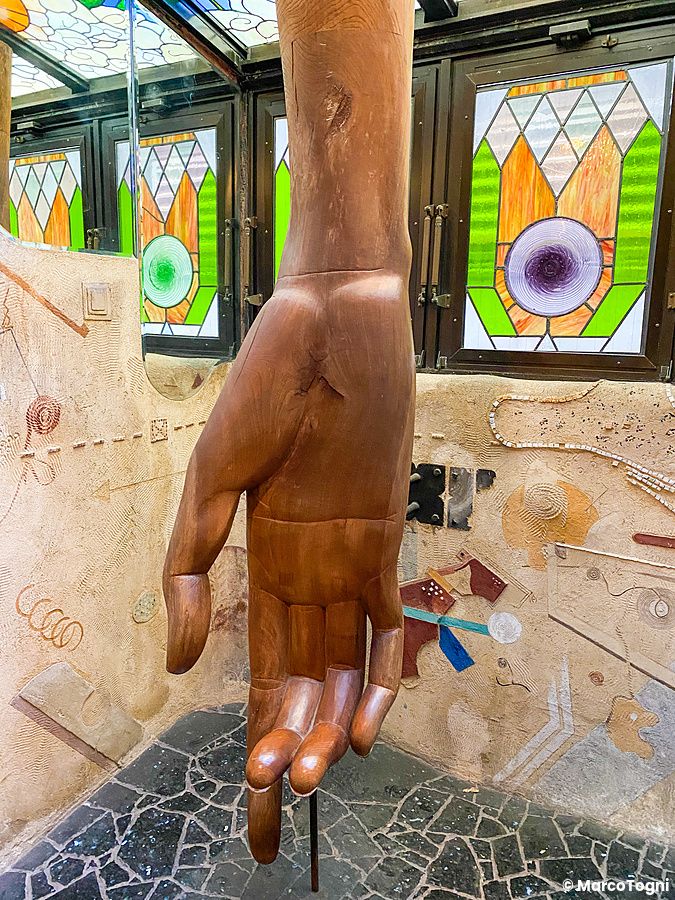Una grande mano di legno scolpita all'interno, al piano terra a El Dorado a Waseda, con vetrate colorate sullo sfondo.