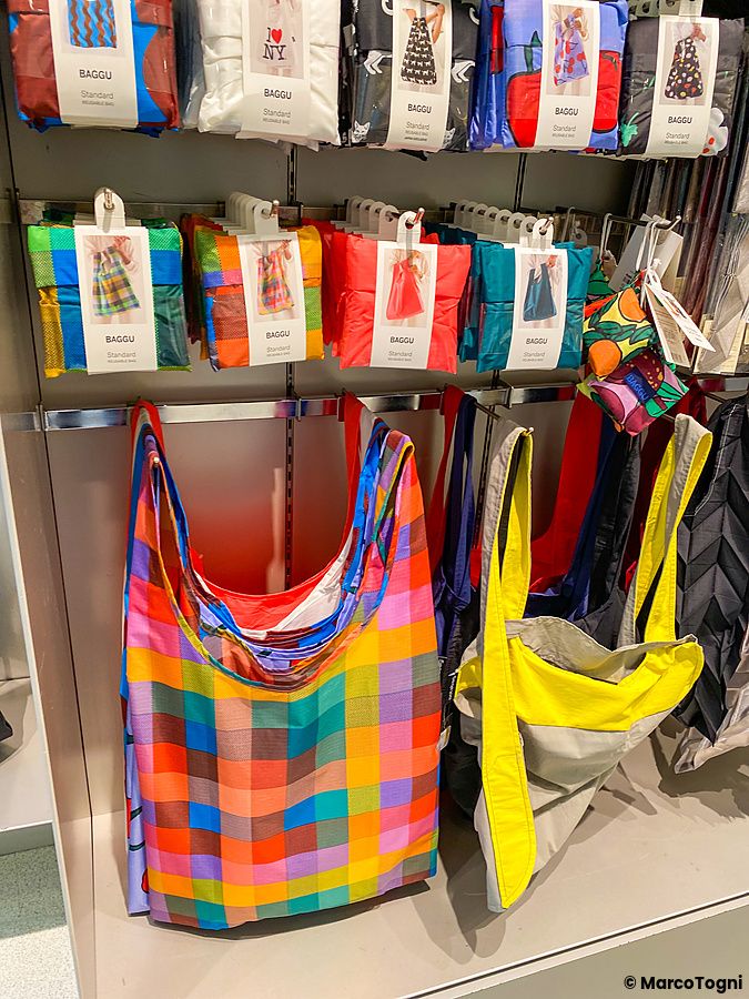 Espositore con borse riutilizzabili colorate e a scacchi del brand Baggu all'interno del Moma Design Store.