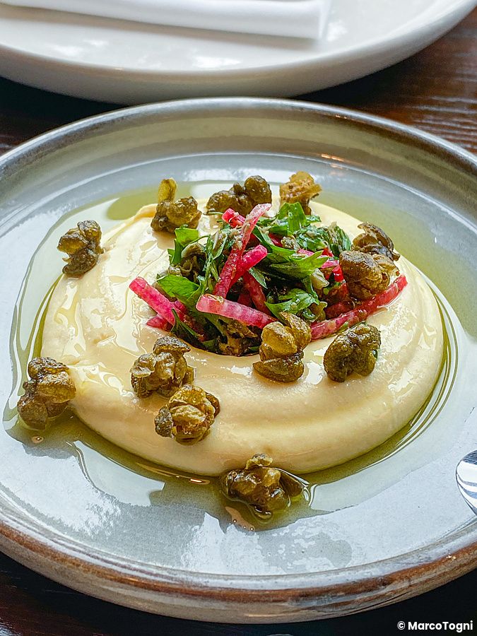 Un piatto con crema, capperi fritti, erbe e ravanello servito al ristorante The Apollo a Ginza.