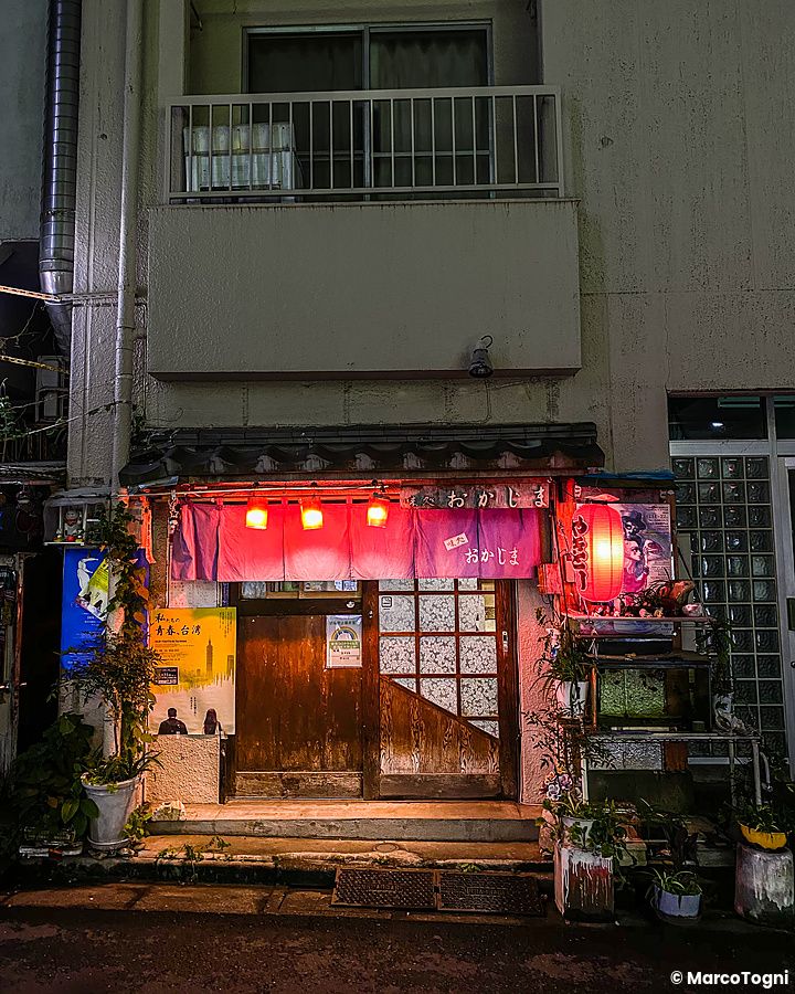 Facciata di una izakaya a Shibuya illuminata da lanterne rosse.