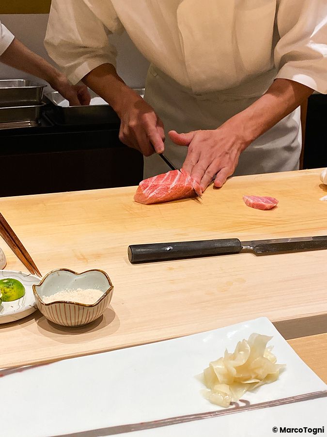 Uno chef al lavoro a Ginza Kyubey taglia un pezzo di tonno su un tagliere in un ristorante di sushi a Tokyo.