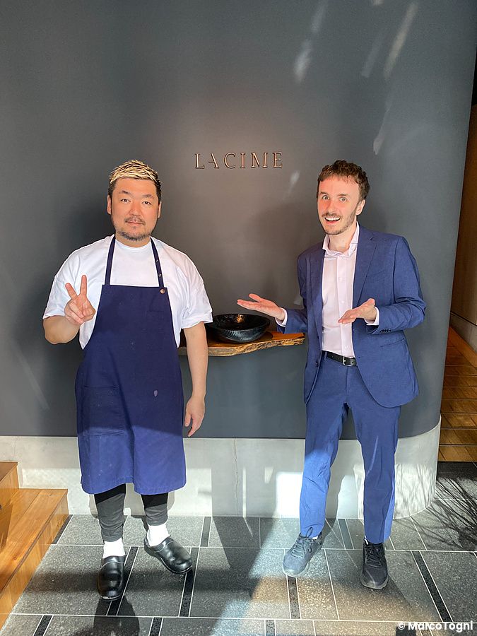 Due persone posano davanti alla scritta La Cime all'interno del ristorante a Osaka.