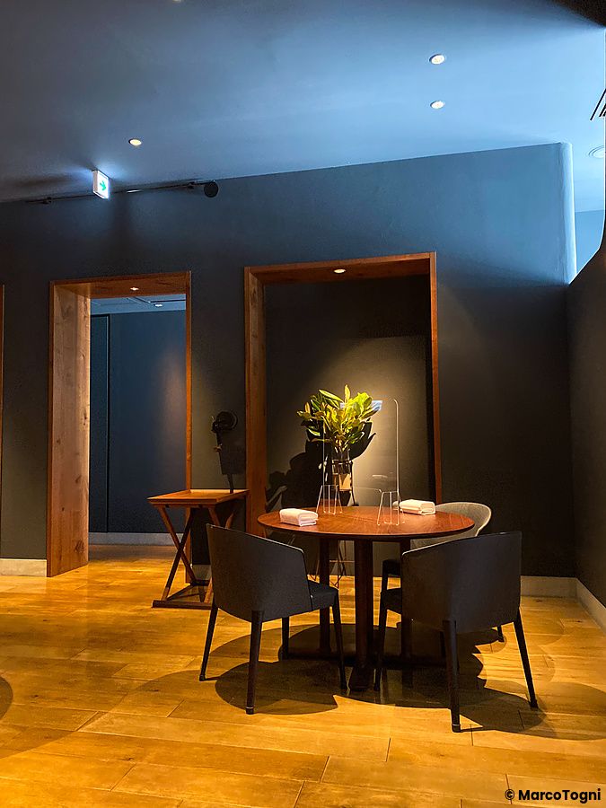 Un tavolo rotondo in legno con sedute scure in un ambiente interno a La Cime caratterizzato da pareti scure e legno.