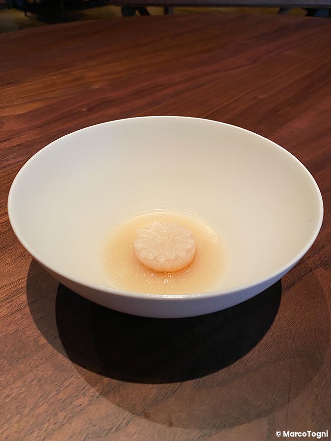 Una zuppa con daikon a fiore e brodo di maiale di Amami servita in una ciotola bianca al ristorante La Cime a Osaka.