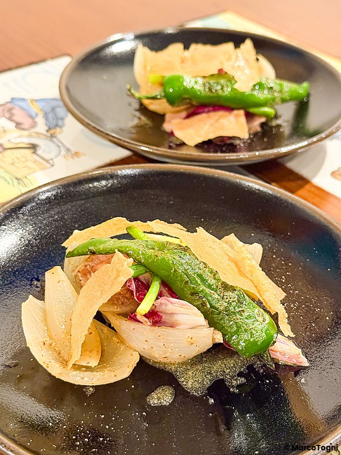 Carne d'anatra con peperoncino e cialde su piatti neri al Ristorante Momose Shokudo.