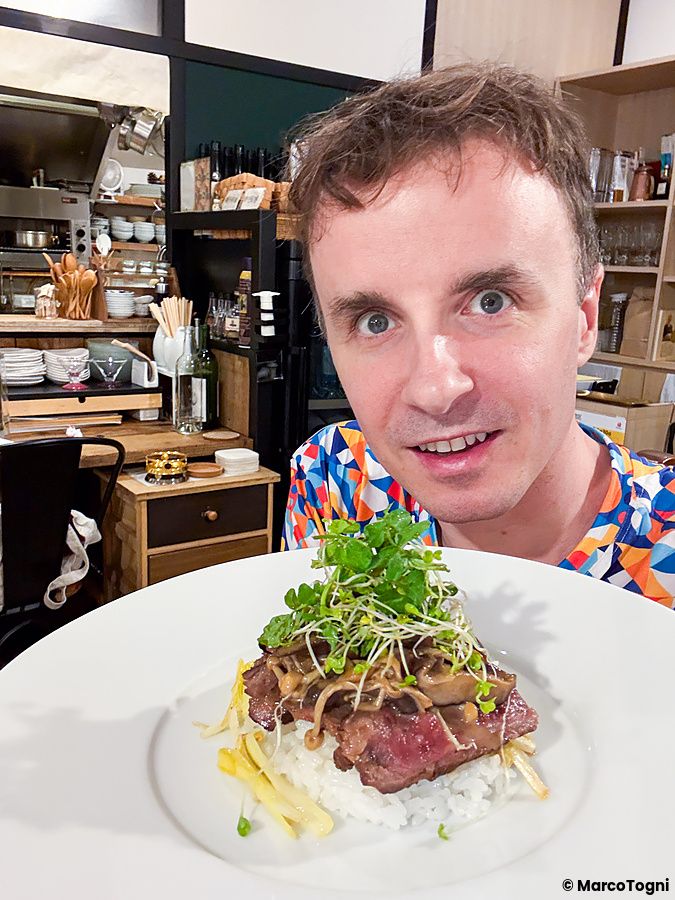 Marco Togni mostra un piatto di carne wagyu con riso e germogli presso il Ristorante Momose Shokudo.