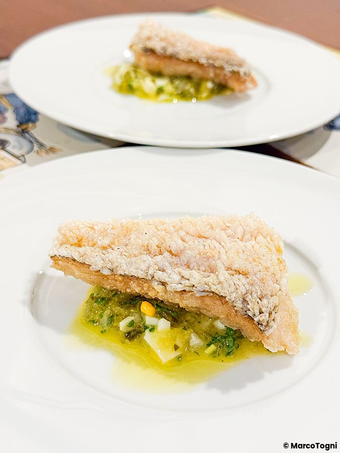 Pesce con frittura matsukasa yaki servito su un piatto bianco al Ristorante Momose Shokudo.