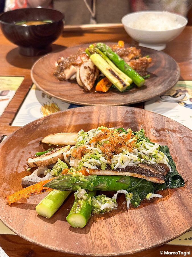 Un piatto di verdure fresche su un tavolo di legno al Ristorante Momose Shokudo.