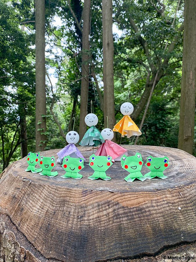 Figure di carta colorate su tronco d'albero sul Monte Takao