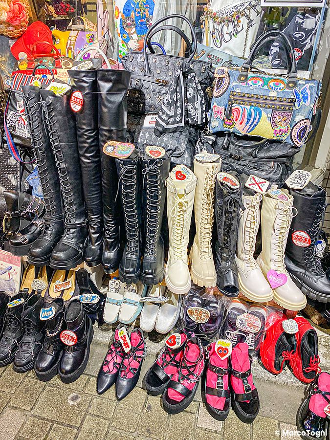 Vetrina di un negozio di calzature con stivali e scarpe alla moda esposti su più livelli a Takeshita Dori, Tokyo.