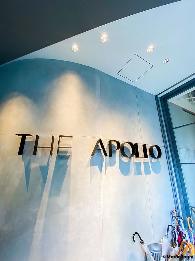 Insegna metallica di The Apollo su una parete grigia curva all'ingresso del ristorante a Ginza, Tokyo.