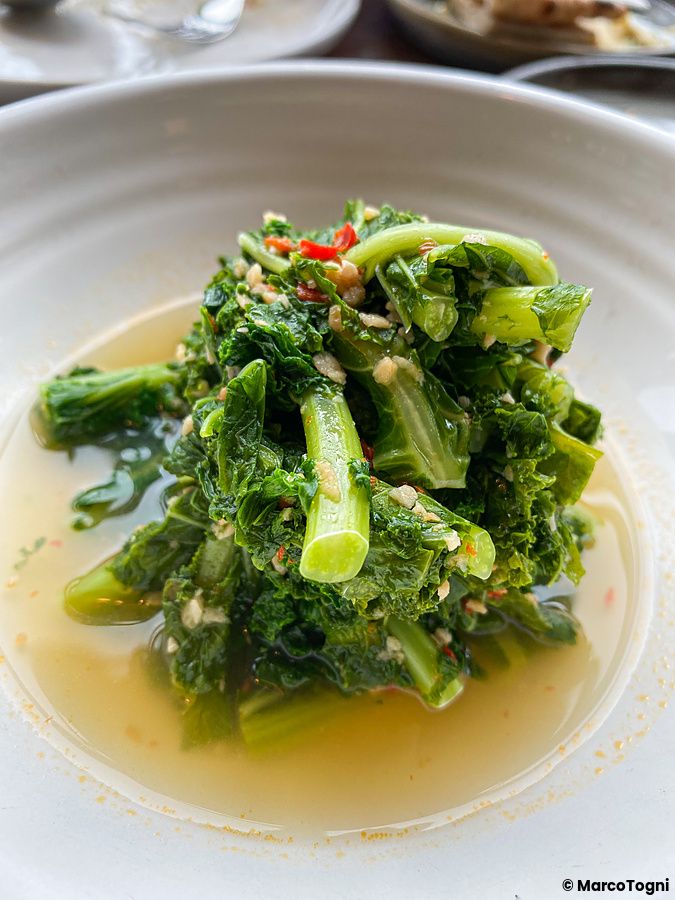 Piatto di verdure a foglia verde saltate in brodo servito al ristorante The Apollo nel quartiere di Ginza a Tokyo.