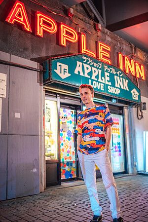 Marco Togni davanti all'insegna illuminata di un love hotel a Shimbashi.