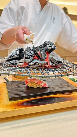 Sushi scaldato da carboni ardenti in un ristorante giapponese.