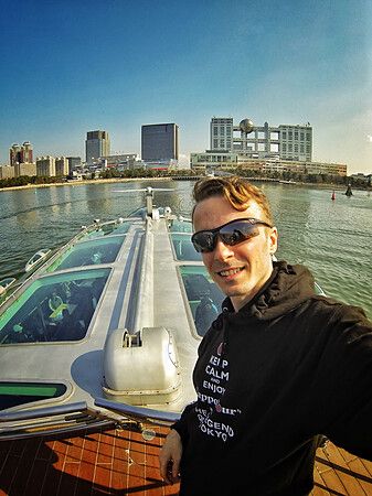 Marco Togni su traghetto Hotaluna verso Odaiba con skyline di Tokyo sullo sfondo.