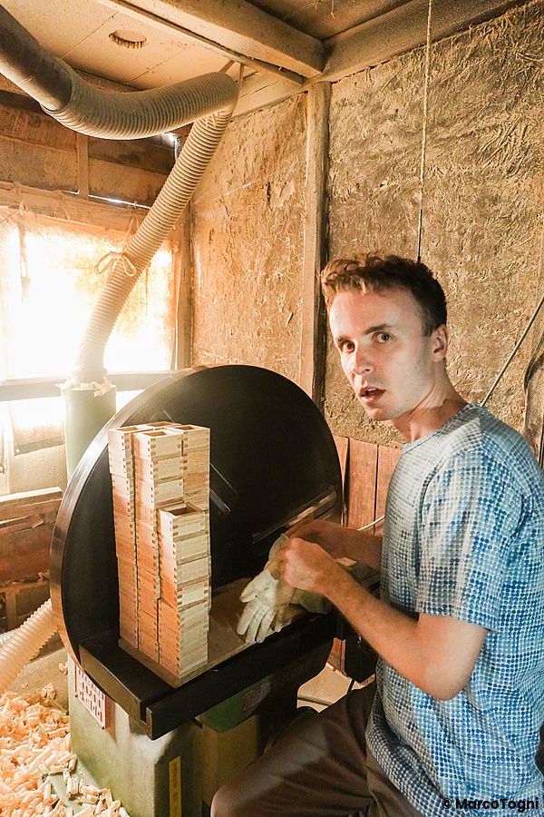 Marco Togni realizza un masu in legno all'interno di un laboratorio di falegnameria.
