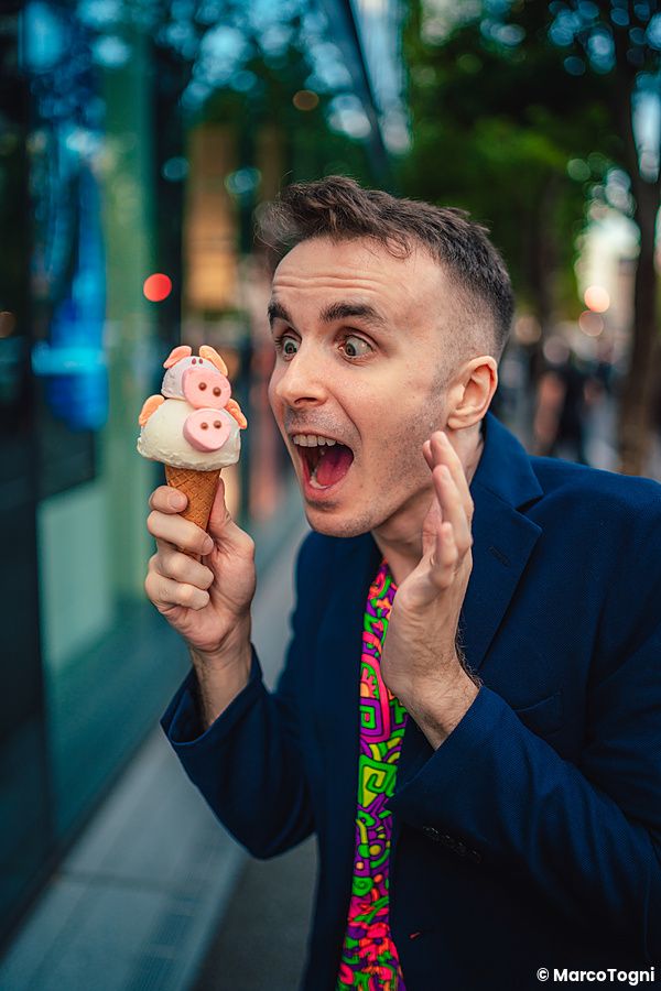 Marco Togni guarda con sorpresa un gelato a forma di maialino tenuto in mano lungo una strada di Harajuku.
