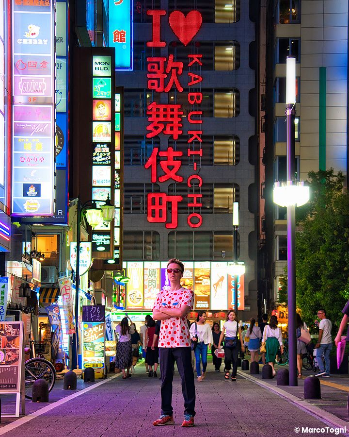 Persona in strada a Shinjuku, circondata da insegne luminose