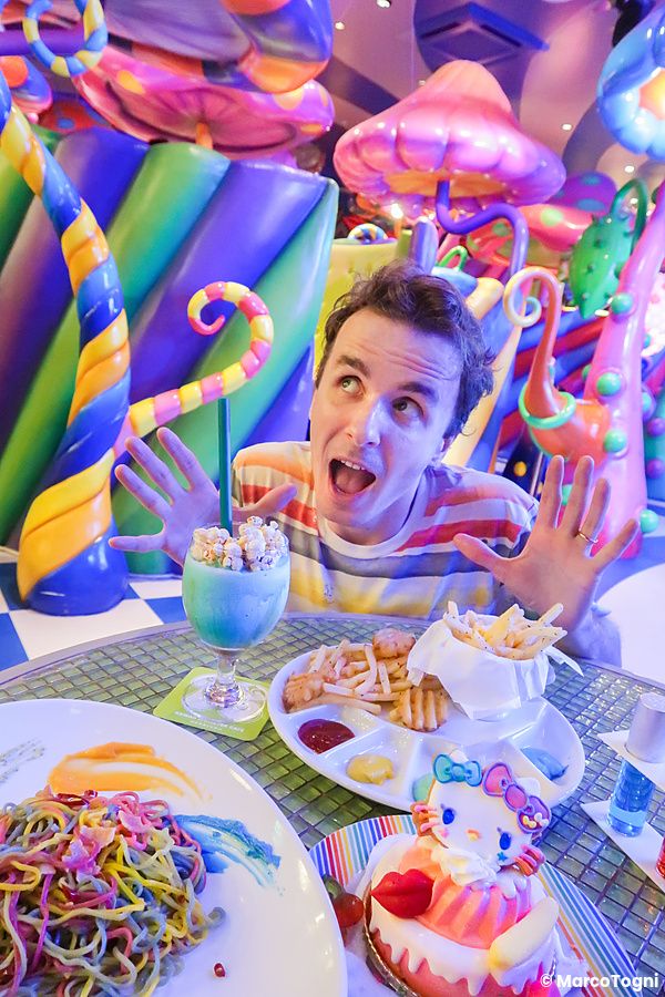 Marco Togni al Kawaii Monster Cafe di Tokyo con piatti colorati e decorazioni kawaii.