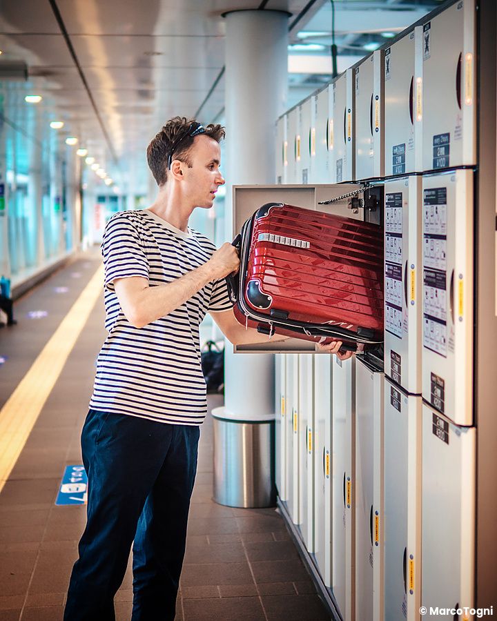 Marco Togni inserisce una valigia rossa in un armadietto di deposito bagagli presso la stazione di Shinjuku a Tokyo.