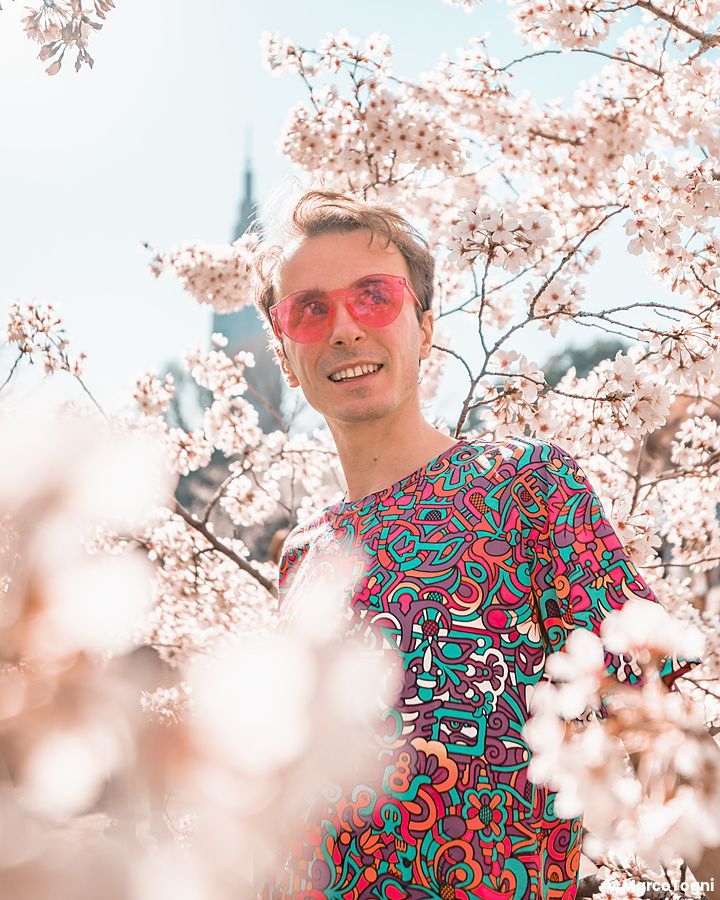 Marco Togni con occhiali rosa tra i fiori di ciliegio allo Shinjuku Gyoen.