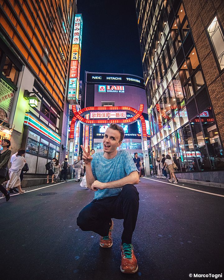 Marco Togni in posa di sera sotto le luci al neon di Shinjuku.