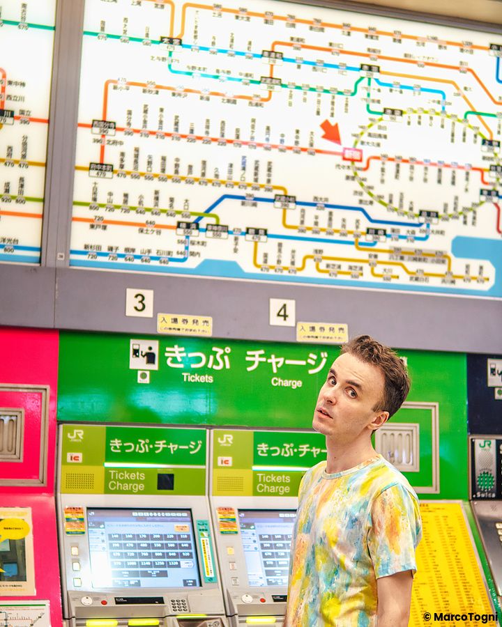 Marco Togni davanti alle macchinette automatiche per i biglietti ferroviari in una stazione di Tokyo.