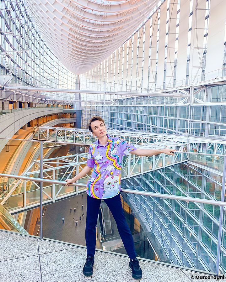 Marco Togni in posa al Tokyo International Forum con architettura moderna.