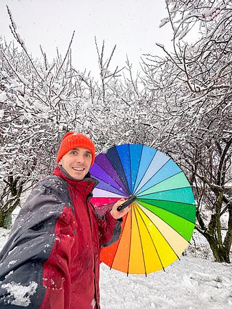 Marco Togni con ombrello colorato sotto neve in Giappone.