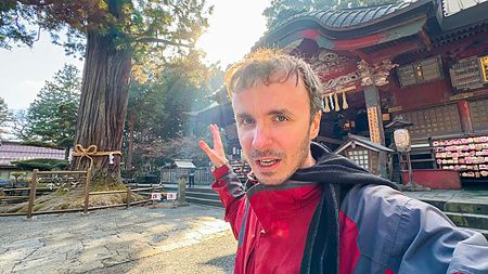 Marco Togni si scatta un selfie davanti all'ingresso in legno del Santuario Kitaguchihongu Fuji Sengenjinja.