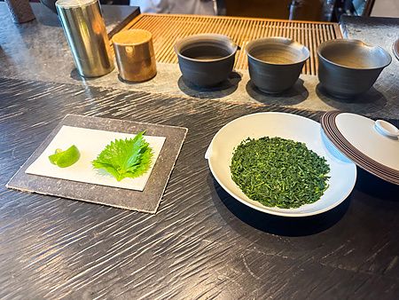 Un banco di lavoro presso Sakurai Japanese Tea Experience a Omotesando con foglie di tè, lime e una foglia di shiso.
