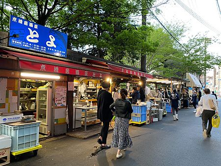 Veduta esterna del Toyo Izakaya a Toyo Izakaya a Osaka con insegna blu e persone che passeggiano lungo la strada.