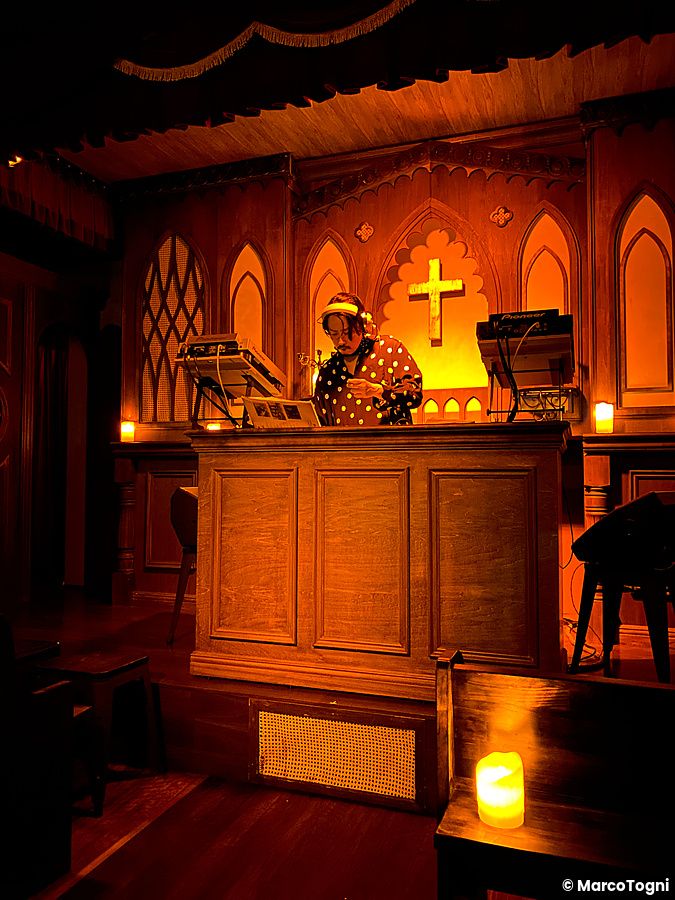 Una persona alla console da dj all'interno di The Church, bar a tema chiesa situato a Shibuya.