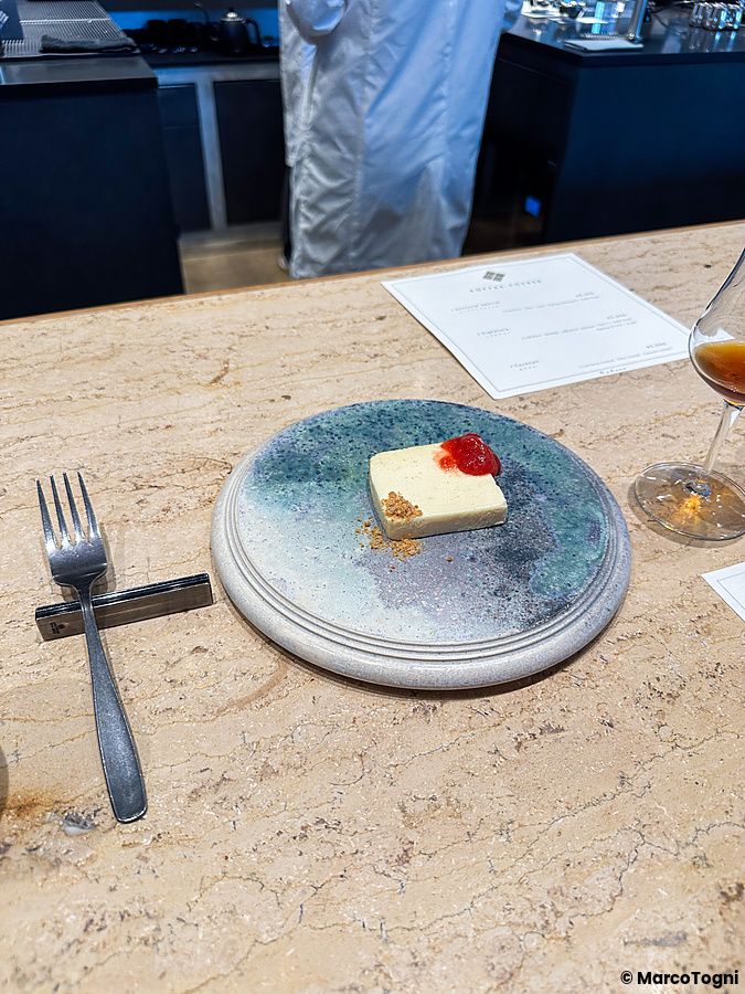 Un dolce a Koffee Mameya Kakeru servito su un piatto artistico in ceramica su un bancone di pietra a Tokyo.